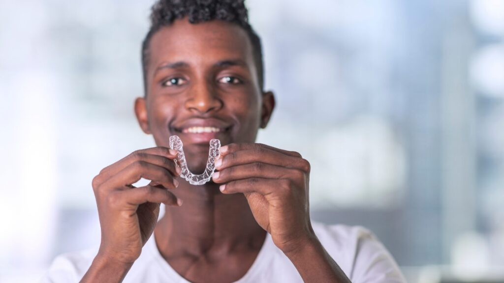 Jeune homme tenant une gouttière d'alignement transparente